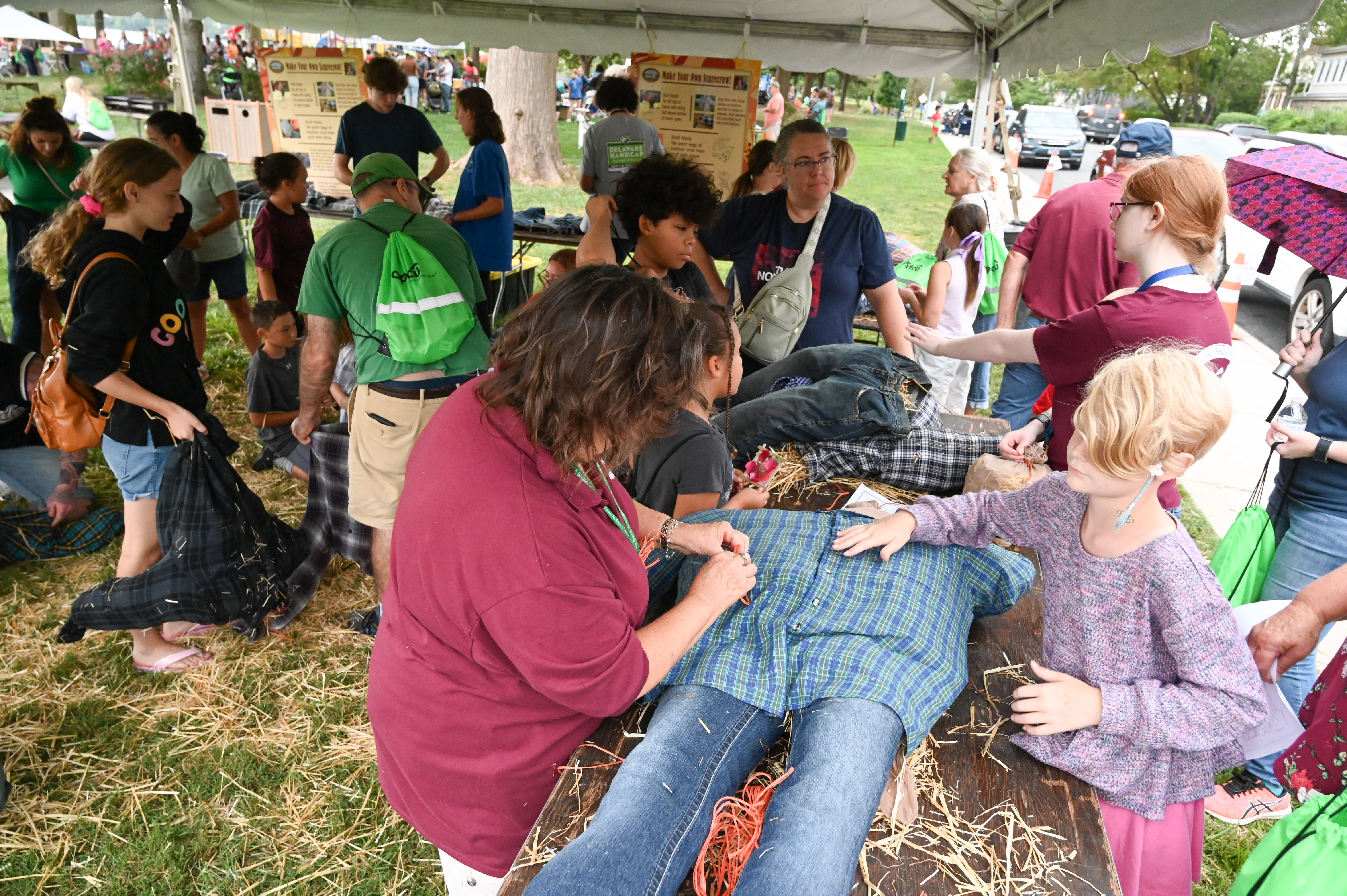 Volunteers with the Steppingstone Farm Museum help children and their families construct scarecrows during the annual Children's Art Festival in Havre de Grace on Saturday. The event was organized by the Havre de Grace Arts Commission with money from the scarecrow making benefitting the Steppingstone Farm Museum as it recovers from a fire earlier this year. (Brian Krista/staff photo)