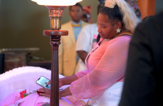 Daonna J. Tucker lays a flower on the chest of her son Leslie Noble IV, the Franklin High School player who collapsed during a team practice Aug. 14. (Karl Merton Ferron/Staff)